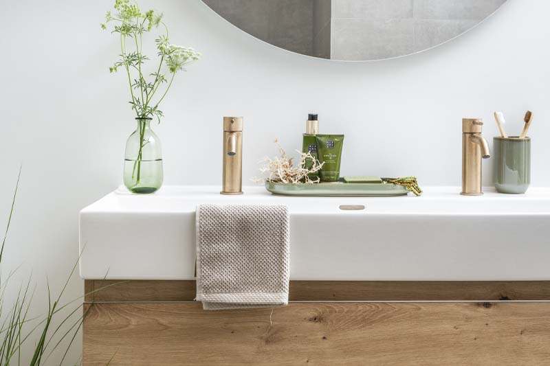 Une salle de bain luxueuse avec des plantes fraîches et une expérience olfactive subtile qui crée une atmosphère calme et raffinée.